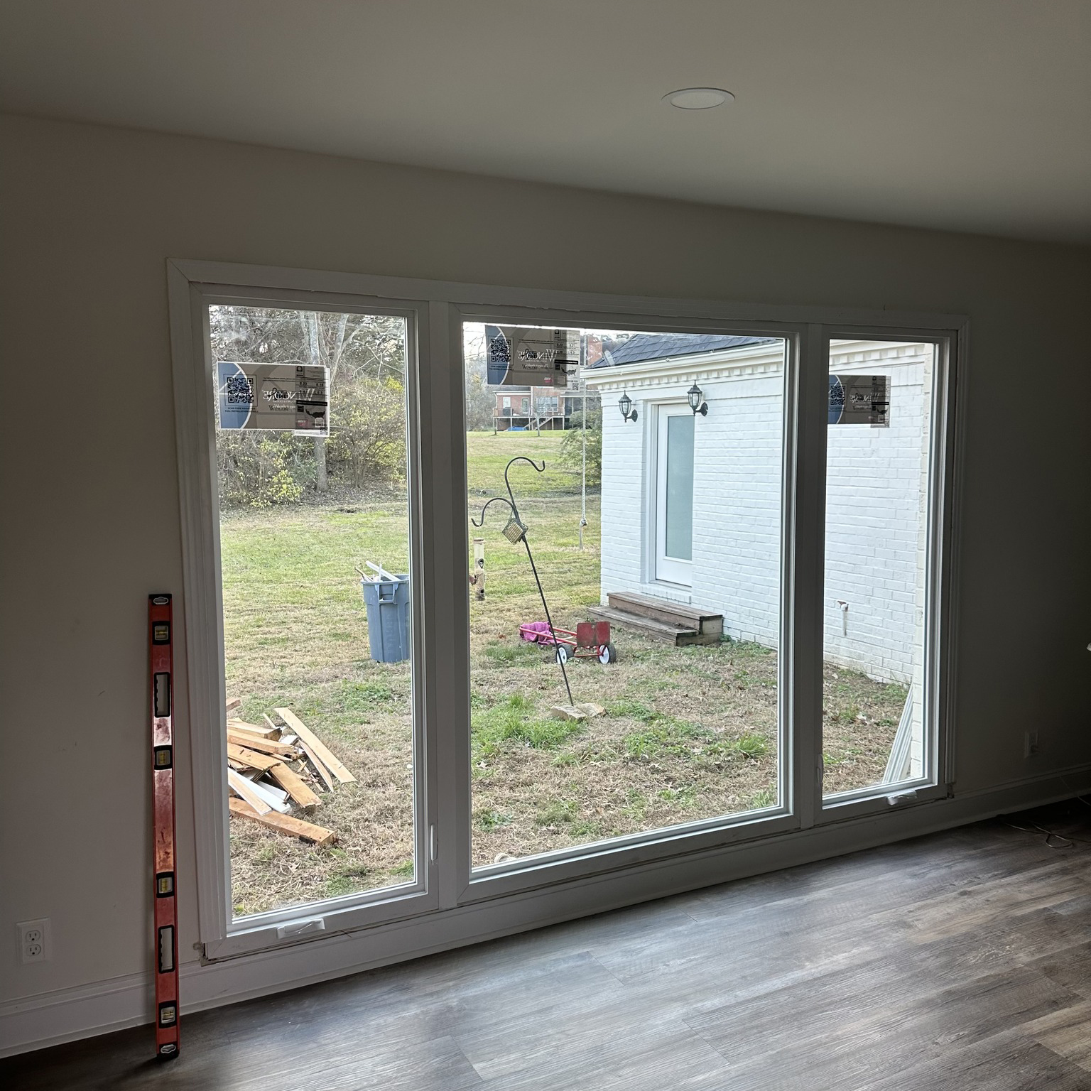 why choose Skylight Windows, Doors, Roofing for Expert Window And Door Replacement in Nashville, TN, Window specialist checking insulated glass performance with precise installation tools, New affordable replacement windows brightening a family room in a suburban home